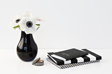 flowers and notebooks in white desk