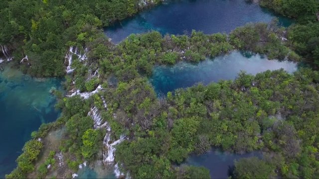 Epic aerial shot over multiple small waterfalls in a beautiful scenic region
