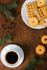 Cup of hot coffee with pastry, Fir branches and coffee beans.