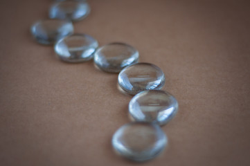 Clear marbles with light reflections on a brown background.