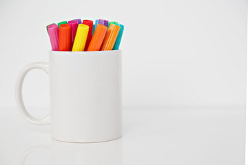 colorful pens in  cup on white background