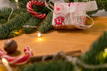 Christmas candys,macadamia nuts and christmas tree branches with a garland in the wooden background