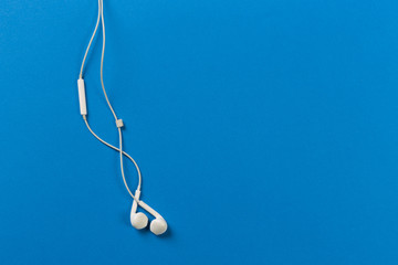 White earphones on blue background