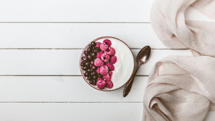 Raspberries and blueberries in a Bowl. Healthy breakfast concept with yoghurt and muesli