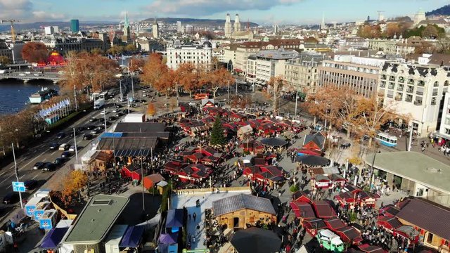 Drone shot of the Christmas Market in Zurich, Switzerland during the day with the cityscape in the background
