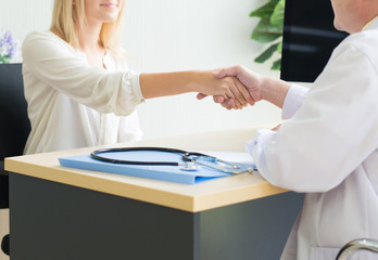 Obraz premium Woman patient giving handshake to man doctor at the hospital