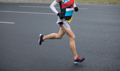 Marathon runner legs running on city road