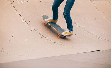 skater legs skating on ramp at skatepark