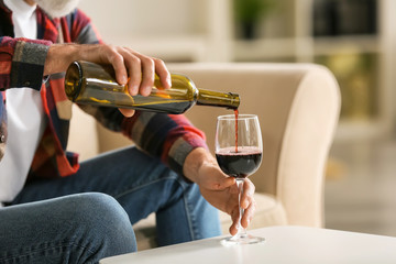 Senior man drinking wine at home - Powered by Adobe