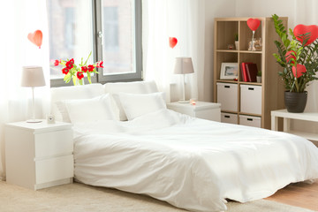 coziness, interior and romantic date concept - cozy home bedroom decorated for valentines day
