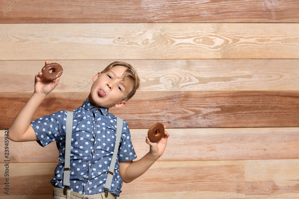 Sticker cute little boy with donuts on wooden background