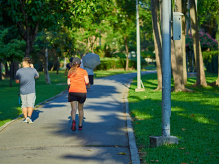 Overweight woman running in the park. Weight loss concept.