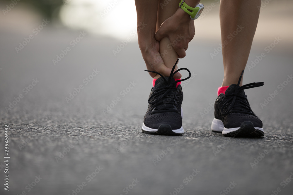 Sticker woman runner hold her injured leg on road