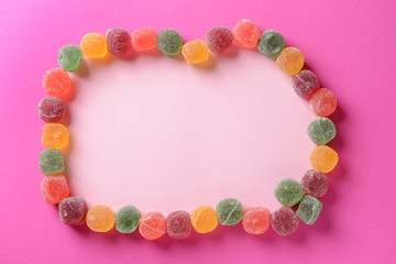 Frame made of sweets on color background
