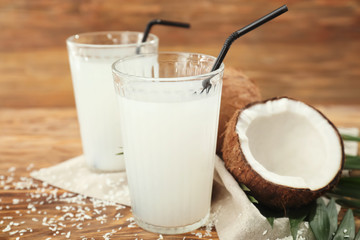 Glasses of tasty coconut water on wooden table