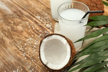 Glass of tasty coconut water on wooden table