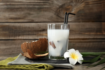 Glass of tasty coconut water on table