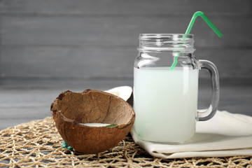 Mason jar of tasty coconut water on table