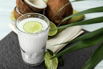 Glass of tasty coconut water on table