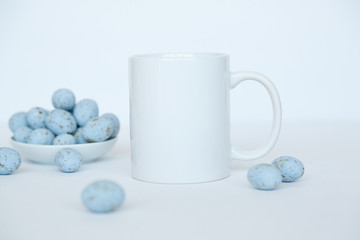 white mug with blue eggs on white background