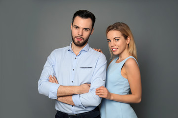 Stylish young couple on grey background