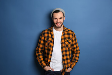 Fashionable young man in checkered shirt on color background