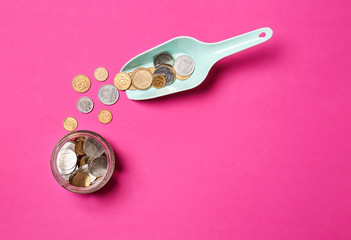 Composition with scoop, money and jar on color background. Savings concept