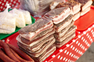 Delicious traditional russian and ukranian meat food (smoked sausage and lard) on the city market table, colorful and tasty. Outdoors, close up, copy space. National cuisine.
