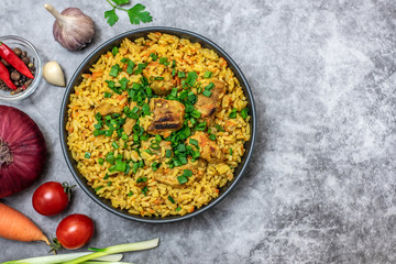 Rice pilaf with meat carrot and onion on grey background. Top view