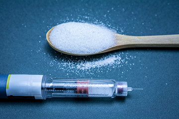 Insulin pen along with a tablespoon of white sugar