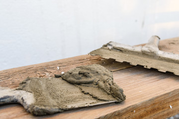 Two spatulas with mortar on old wooden board