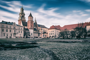 Fototapeta premium Wawel royal castle in Krakow, medieval fortress, stunning architectural ensemble on the Wawel hill, vintage image with dramatic cloudy sky, travel outdoor background, Poland, Europe