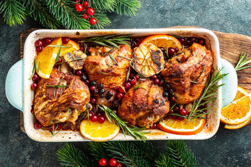 Christmas turkey legs baked with cranberries, orange and rosemary. Delicious festive dish for Christmas time. Top view,  flat lay