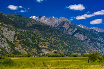 Fototapeta na wymiar Fields and meadows with Swiss Alps mountains, Agarn, Leuk, Visp,