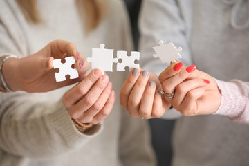 People holding pieces of jigsaw puzzle