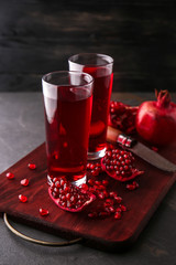 Glasses of tasty pomegranate juice on table