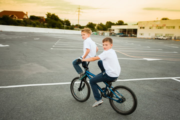 Fototapeta na wymiar Two brothers showing their skills riding on one bike
