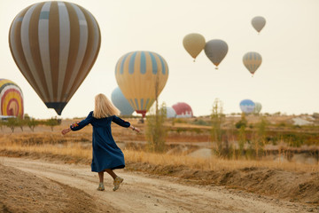 Obraz premium Woman Having Fun With Flying Hot Air Balloons On Background