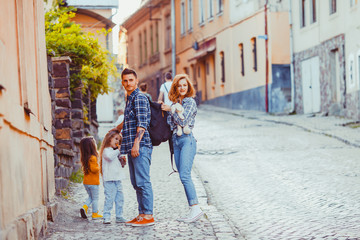 Fototapeta na wymiar Lovely family of travelers standing on the ancient street