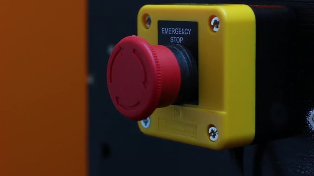 Static Close Up Fist Hitting Emergency Stop Button.