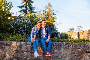 Young couple sitting on a stone wall