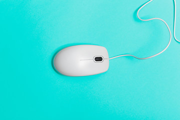 Computer mouse on a turquoise paper background