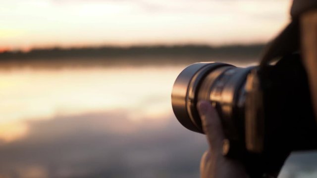 Adventure photographer taking pictures at sunrise