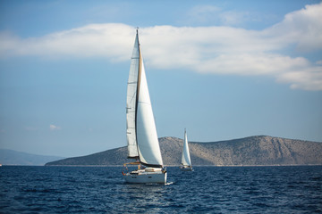 Obraz premium Sailing luxury yacht boats glide on the water surface of the Aegean Sea, Greece.