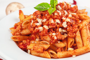 Pasta with meat, tomato sauce and vegetables on the table