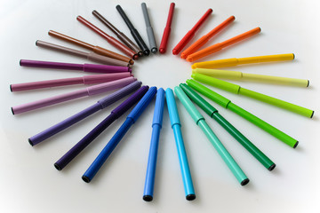 colored pencils, felt-tip pens, markers on a white background, a color palette, a rainbow, office supplies, a range