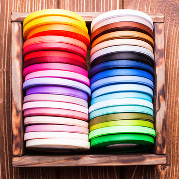 ribbon bobbins in the wooden box close up