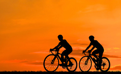 Fototapeta premium Silhouette group friend and bike relaxing on blurry sunset background