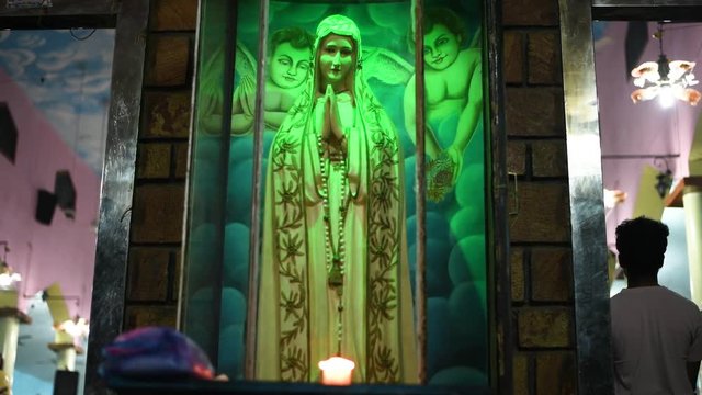 candles in front of god in church people praying jesus in church pastor blessings and reading bille message to devotees rural church in india asia