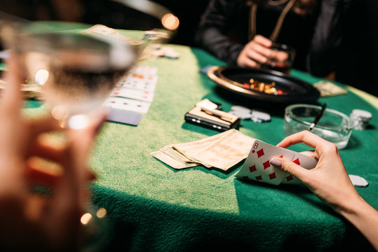cropped image of women playing poker together at table in casino